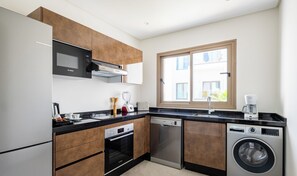 Een moderne keuken met Bosch apparatuur, waaronder een magnetron, oven, vaatwasser en wasmachine.