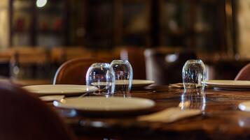 Una mesa de comedor con platos y vasos vacíos, lo que sugiere un ambiente de restaurante.