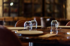 A dining table with empty plates and glasses, suggesting a restaurant setting. - Alda Corrubedo (Ribeira)