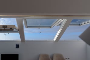 A room with skylights, a bed, and a sign on the wall. - Alda Corrubedo (Ribeira)