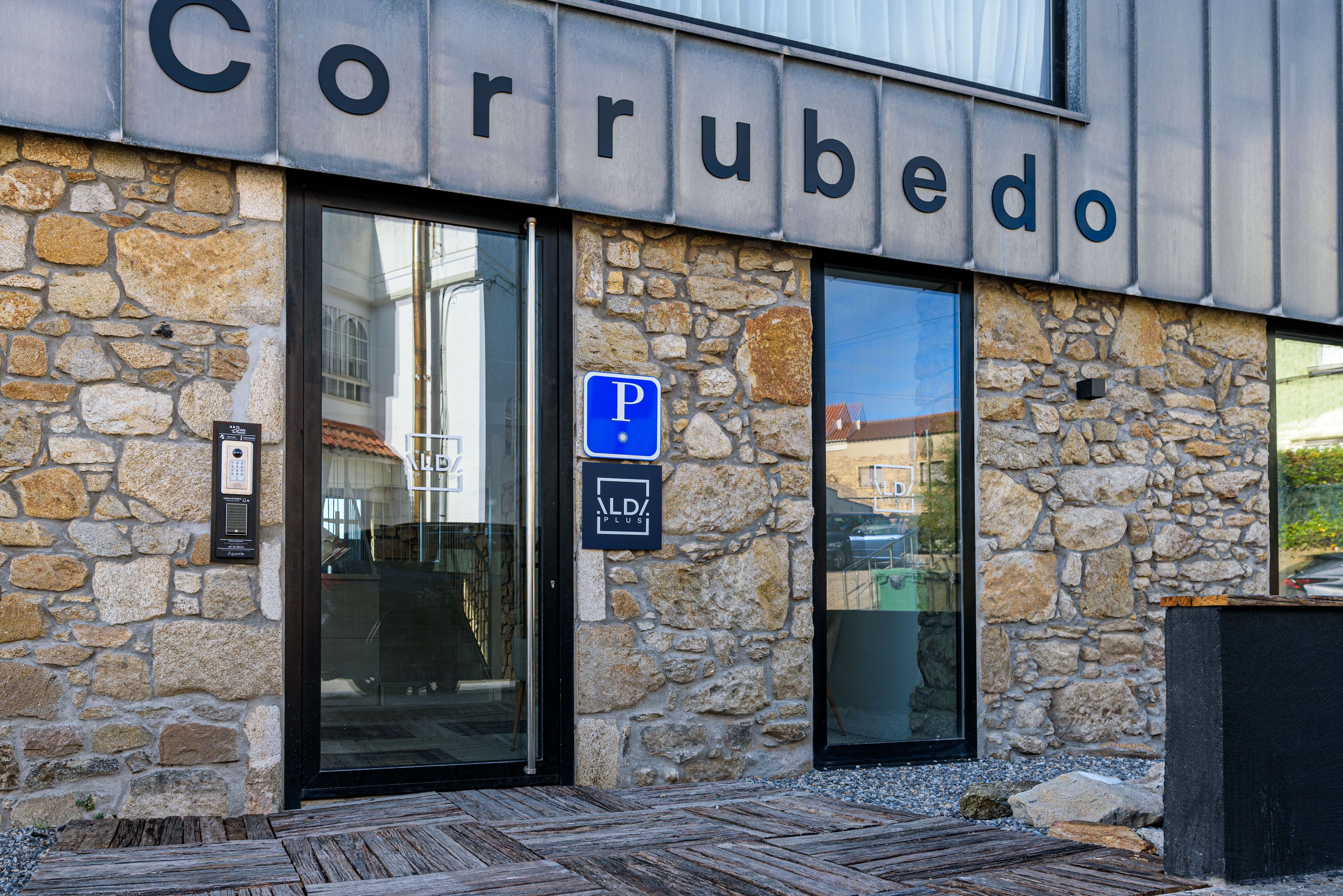 A building with a stone facade and a sign reading "Corubedo".