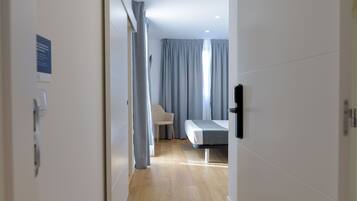 Una habitación de hotel moderna con una cama, una silla y un escritorio.