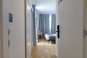 A modern hotel room with a bed, a chair, and a desk. - Alda Corrubedo (Ribeira)