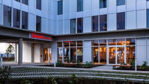 Un hôtel moderne doté d’une entrée bien visible, de grandes fenêtres et d’un espace extérieur bien entretenu.