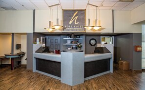 A reception desk with a sign reading "Hope Hotel Conference Center" and a clock on the wall.