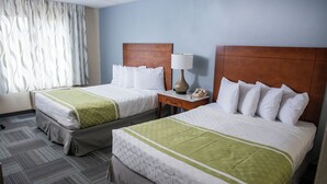 A hotel room with two beds, a nightstand with a lamp, and a telephone. - Hope Hotel & Conference Center (Dayton)