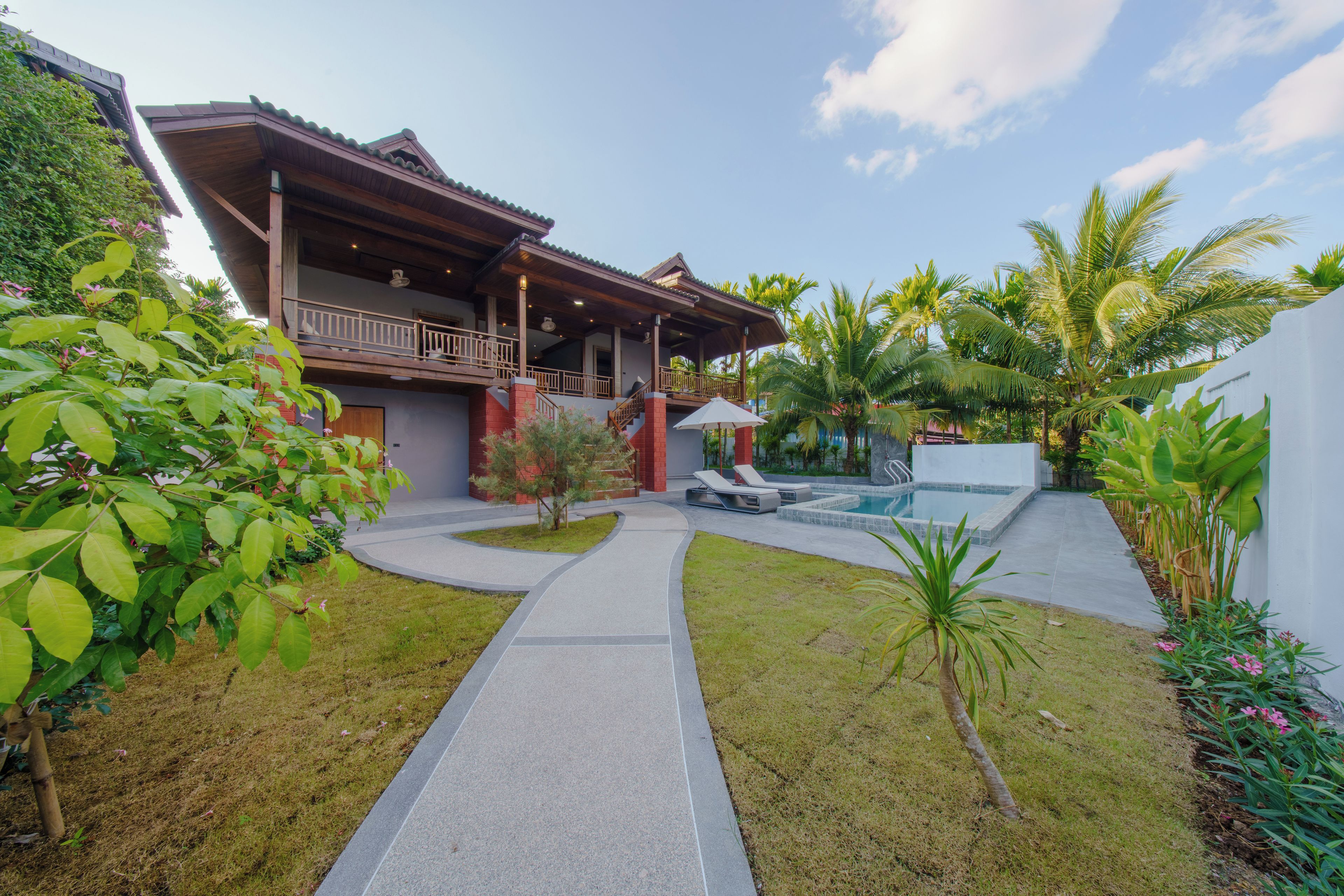 A modern house with a covered porch, a swimming pool, and a well-maintained garden.