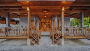 A wooden covered walkway with a central staircase leading to a covered area, surrounded by a white fence and greenery. - Calisto Valley I Luxury Pool Villa Krabi (Krabi)