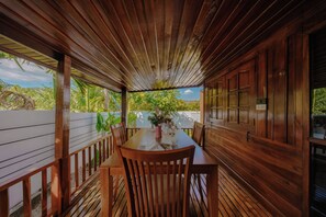 A wooden deck with a table and chairs, surrounded by wooden walls and a white fence. - Calisto Valley I Luxury Pool Villa Krabi (Krabi)