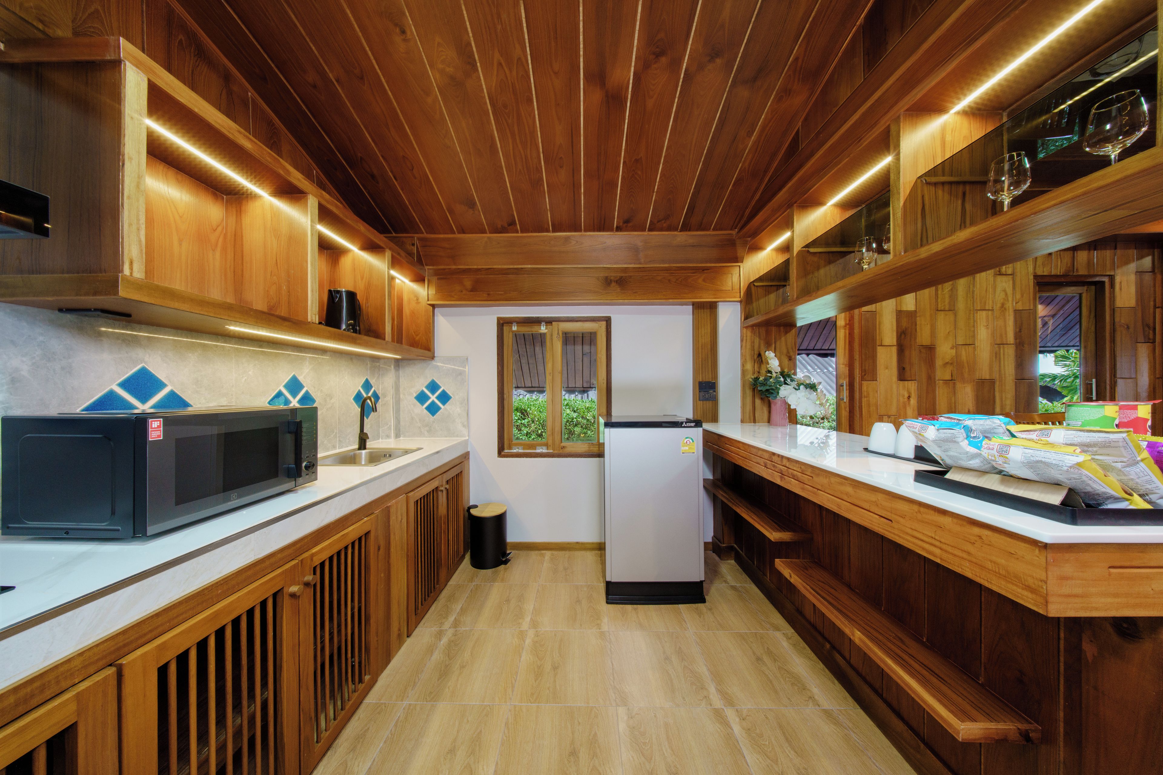A kitchen with wooden cabinets, a microwave, a refrigerator, and a countertop with papers.