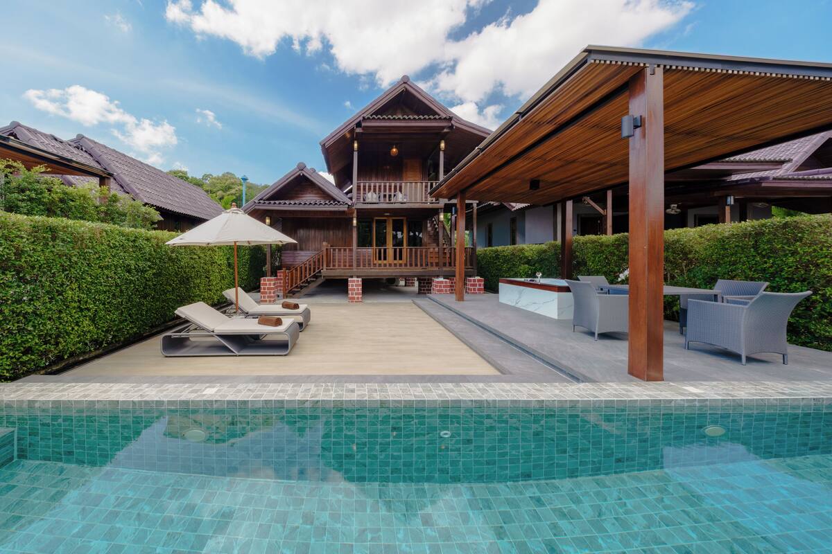 Un resort con piscina, lettini e area relax all'aperto.