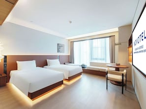 A hotel room with two beds, a desk, and a large window. - Novotel Xiamen International Convention Center (Xiamen)