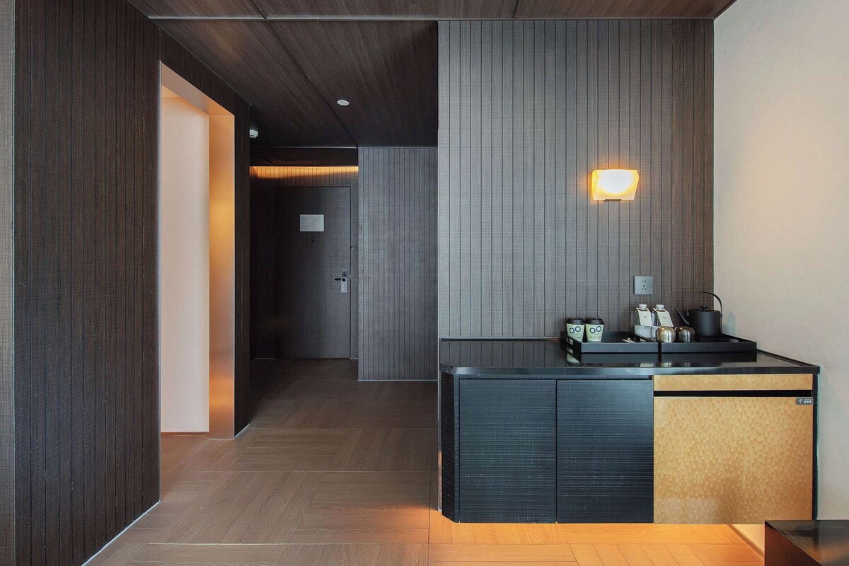 Eine moderne Hotelhalle mit Holzboden, einer Rezeption und einer Wandleuchte.