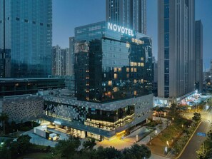 A modern hotel with a glass facade and the name 'NOVOTEL' prominently displayed. - Novotel Xiamen International Convention Center (Xiamen)