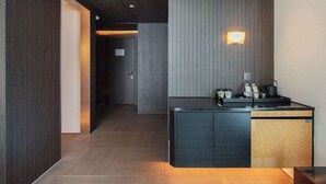 Un moderno vestíbulo de hotel con piso de madera, un mostrador de recepción y una lámpara fijada a la pared.