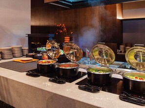 A buffet setup with multiple hot food stations, each with a covered pot and serving utensils. - Novotel Xiamen International Convention Center (Xiamen)