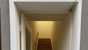 A staircase leading to a landing with a door on the left.