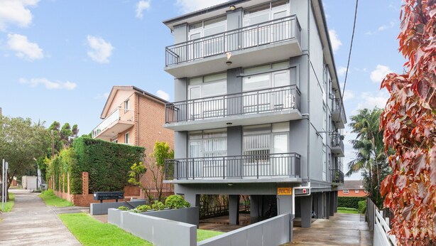 A multi-story residential building with balconies, a paved walkway, and a garden area. - Bright 2-bed Flat With Balcony in Vaucluse (Sydney)