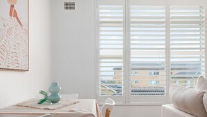 A room with a striped tablecloth, a green vase, and a sofa. - Bright 2-bed Flat With Balcony in Vaucluse (Sydney)