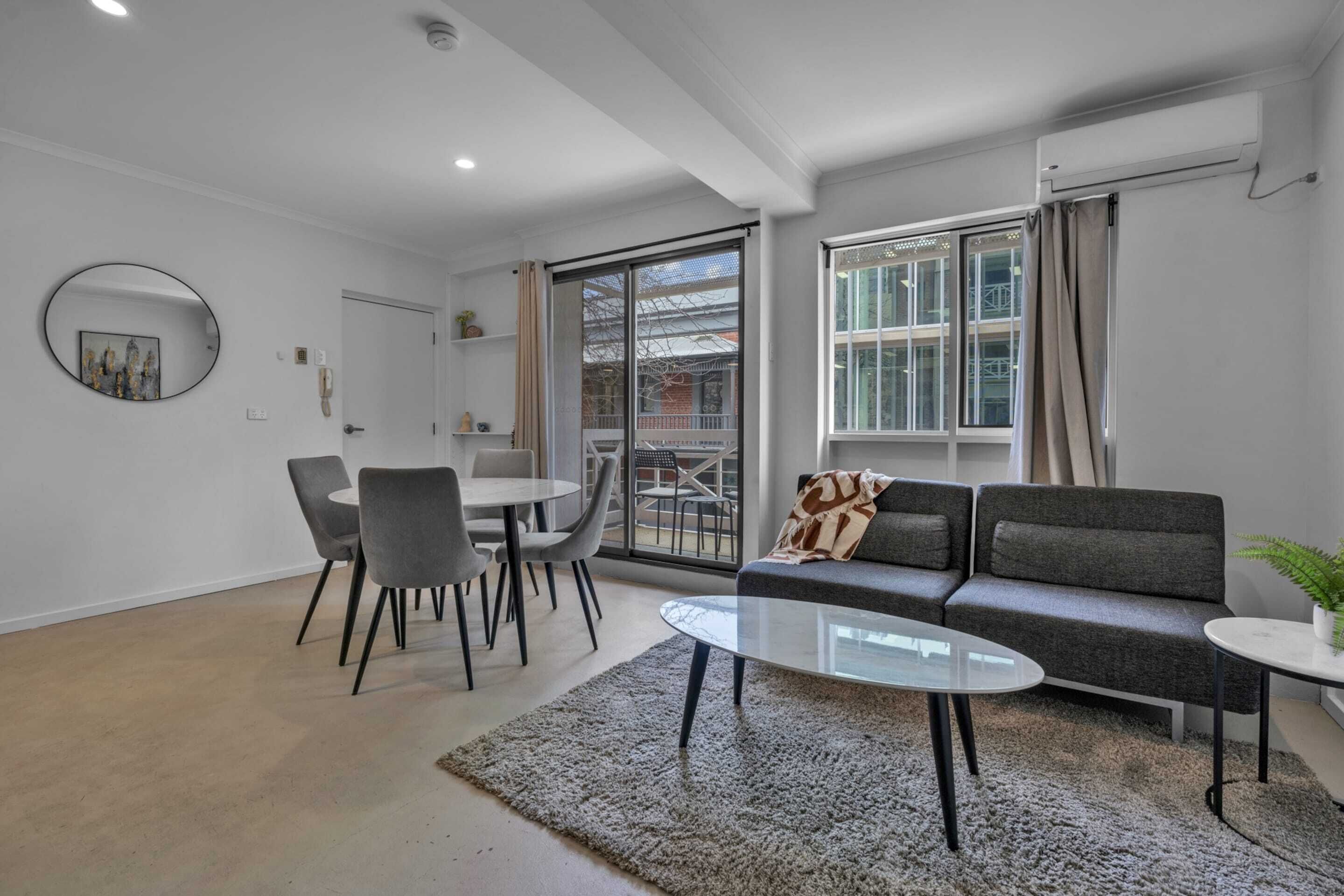 Un salon moderne avec un canapé, une table basse et un coin repas.