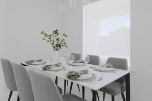 A dining table set with plates, glasses, and cutlery, surrounded by chairs, with a plant in a vase on the table. - Is This Cape`s Best Secret? | 4BR Midnight Pool (Cape Coral)