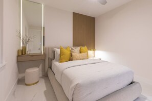 A modern bedroom with a large bed, bedside tables, a mirror, and a wall-mounted panel. - Is This Cape`s Best Secret? | 4BR Midnight Pool (Cape Coral)