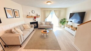 Un salon avec un canapé, une table basse, une cheminée et un téléviseur.