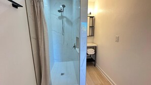 Een douche, handdoeken, zeep, toiletpapier