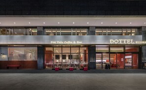 A modern building with a coffee shop named "Dot Telus Coffee & Bar" on the ground floor. - DOTTEL HOTEL (Shantou)