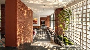 A modern interior with a staircase, a seating area, and a wall with a grid pattern. - DOTTEL HOTEL (Shantou)