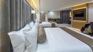 A modern hotel room with a large bed, a desk, and a TV.
