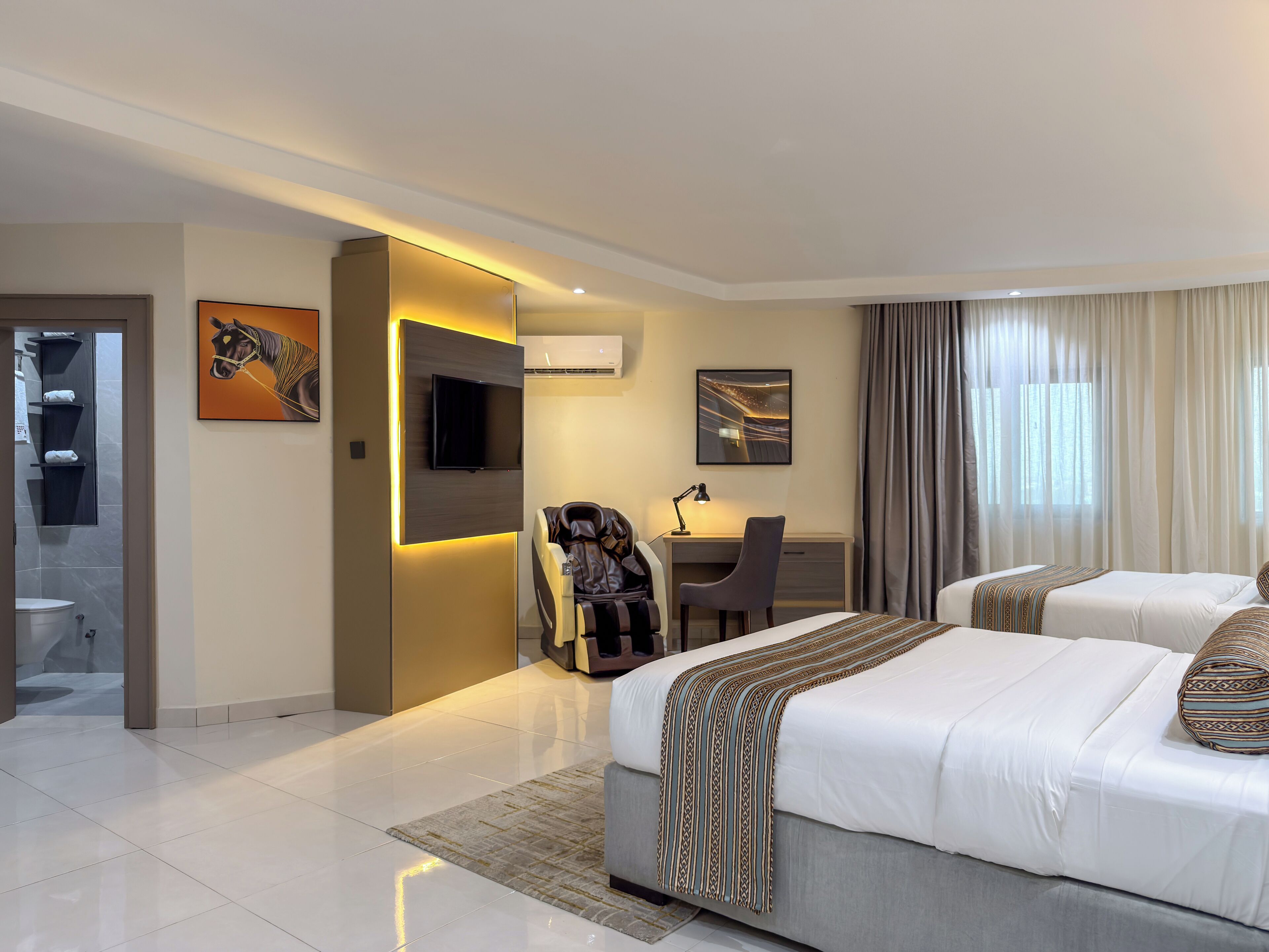 Une chambre d’hôtel moderne équipée d’un lit, d’un bureau, d’une chaise et d’un téléviseur.