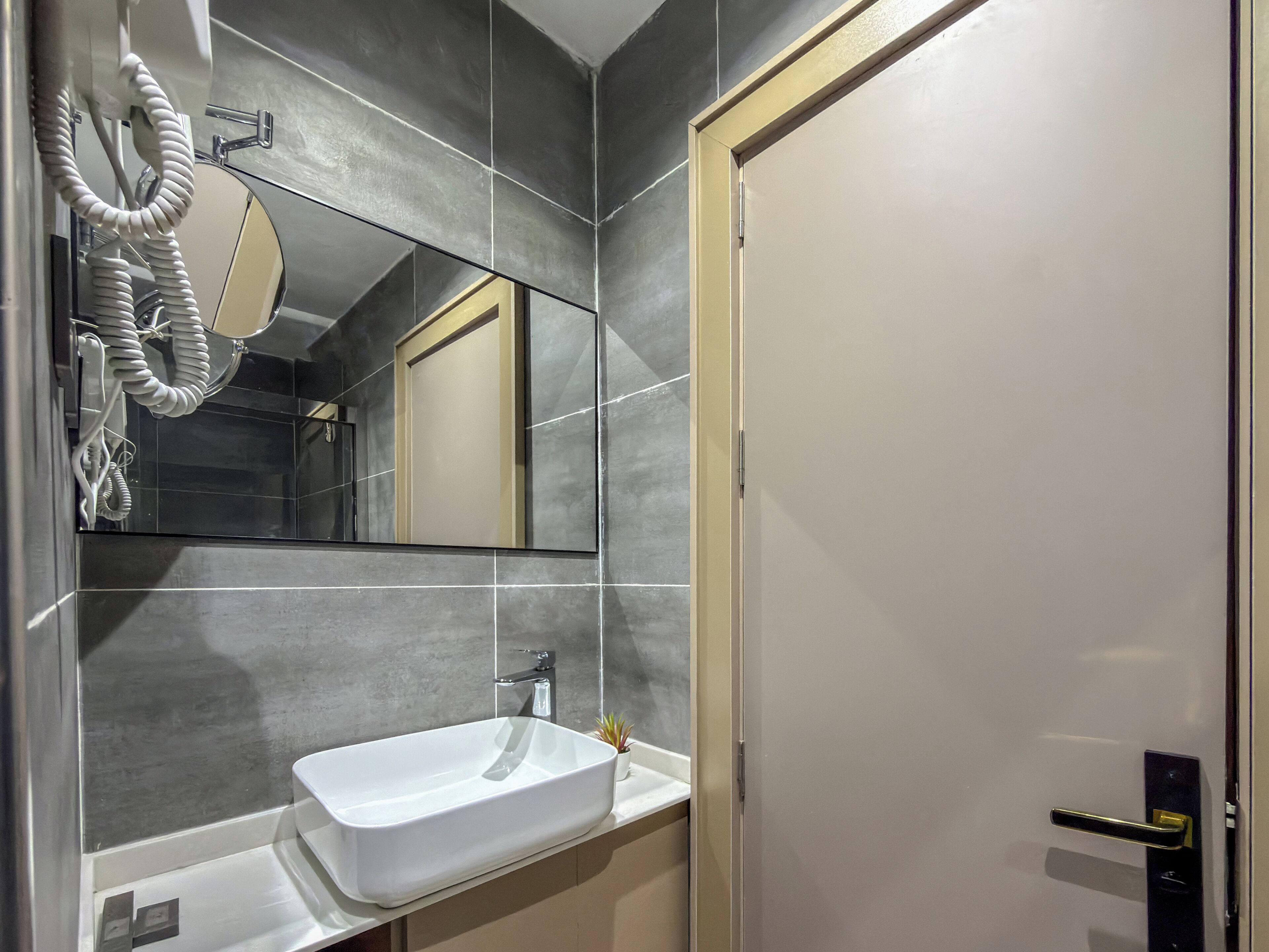 A bathroom with a white sink, a mirror, and a towel rack.