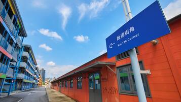A building with a blue sign indicating the direction to the Kai Tak Corner.