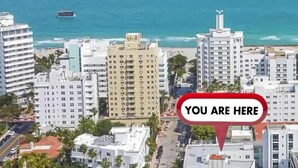 An aerial view of a coastal city with high-rise buildings, a marina, and a clear blue sky. - Indian Creek (Miami Beach)