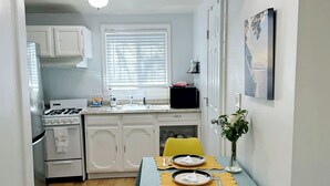 A compact kitchen with white cabinets, a stove, and a window with blinds. - Welcoming studio in El Cerrito for a cozy getaway (El Cerrito)