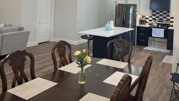 A modern kitchen with white cabinets, a black and white backsplash, and stainless steel appliances. - AG Ranch in Hempstead (Hempstead)