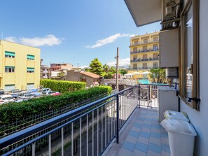 Un balcon donnant sur un parking, une piscine et les bâtiments environnants.