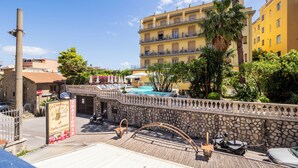 Un hotel con piscina, mobiliario exterior y una pared de piedra.