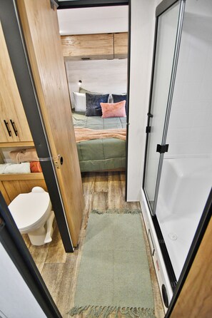 A compact bedroom with a bed, a bedside table, and a small window. - The Ponderosa Perch, a modern tiny home nestled in the pines of Elizabeth (Elizabeth)