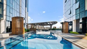 A modern building with a large indoor pool, wooden cylindrical structures, and a unique roof design. - Spacious Modern Apartment With Pool & Gym Access (Melbourne)