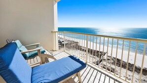 A balcony with a view of the ocean, a white railing, and two blue lounge chairs. - Beach Club B1805 Pools-54-ft balcony K/K/K/K/Bonus room with Q & Tw-XL Sleeps 11 (Gulf Shores)