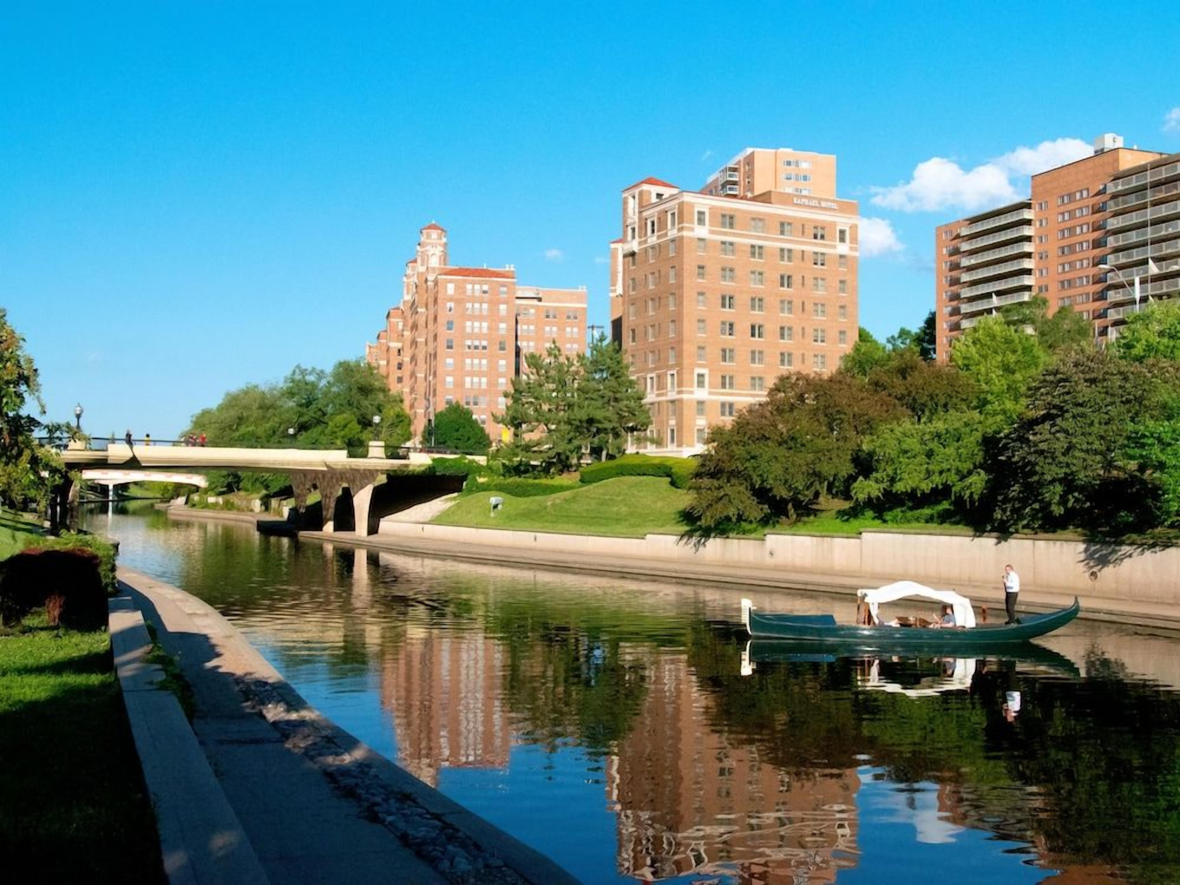 A river with a bridge, buildings, and a boat.