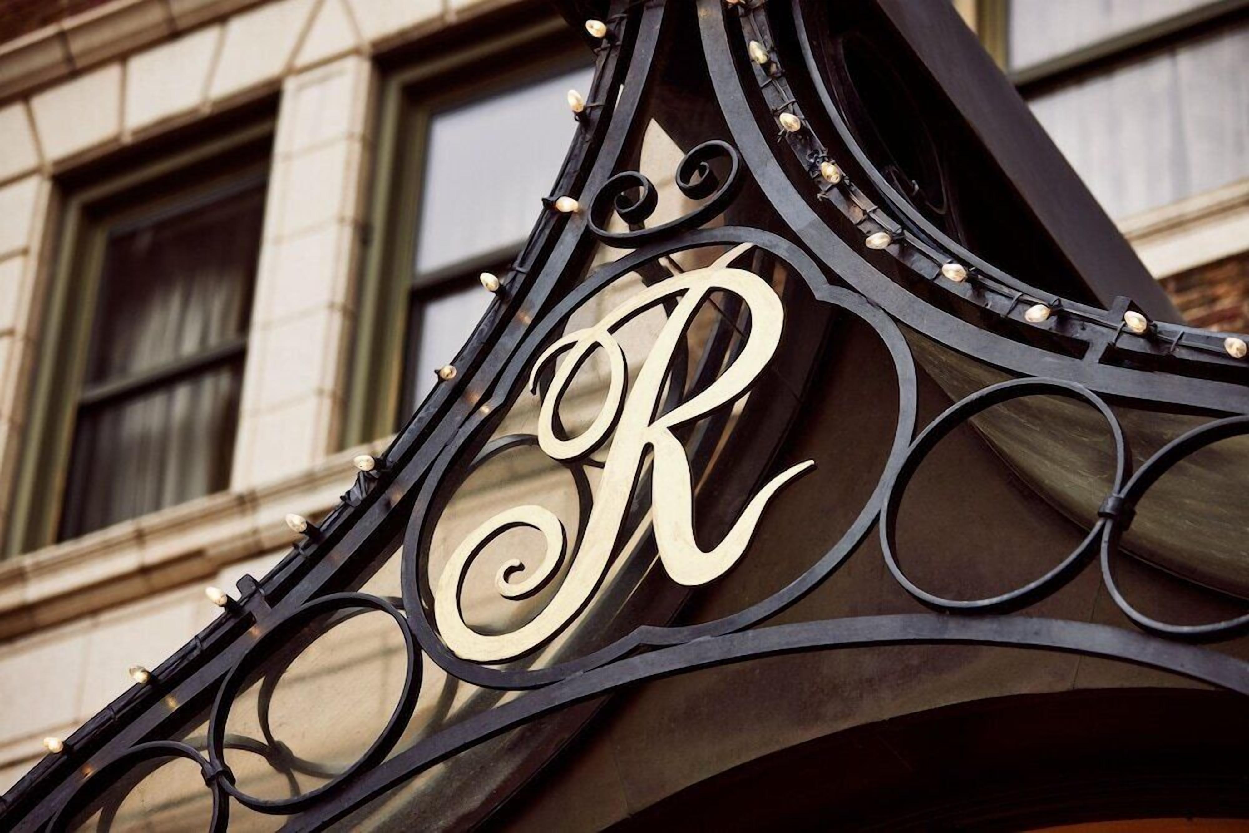 Un gros plan d’une enseigne en fer forgé sur laquelle la lettre « R » est bien visible.