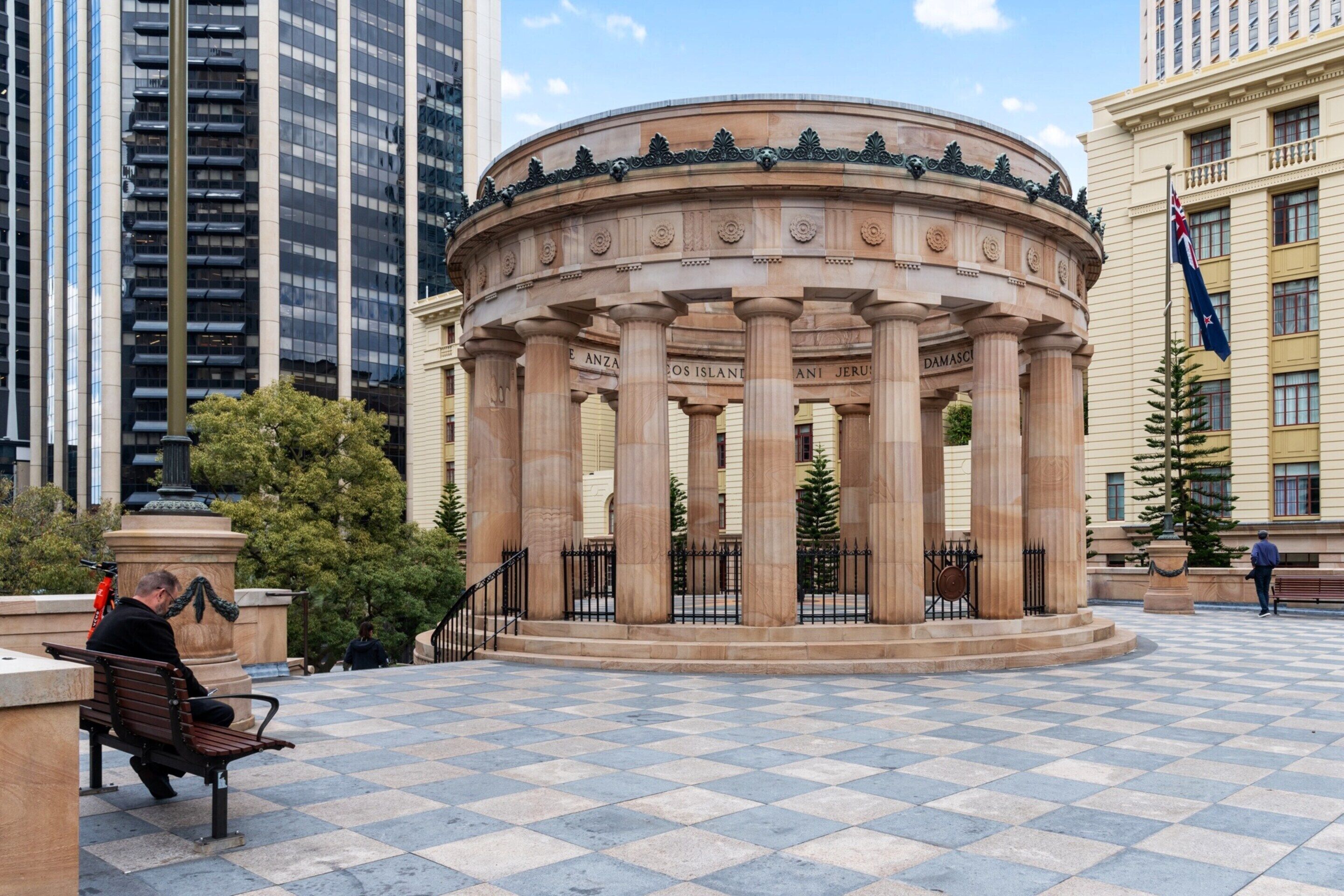 A circular building with columns, surrounded by a checkered pavement.
