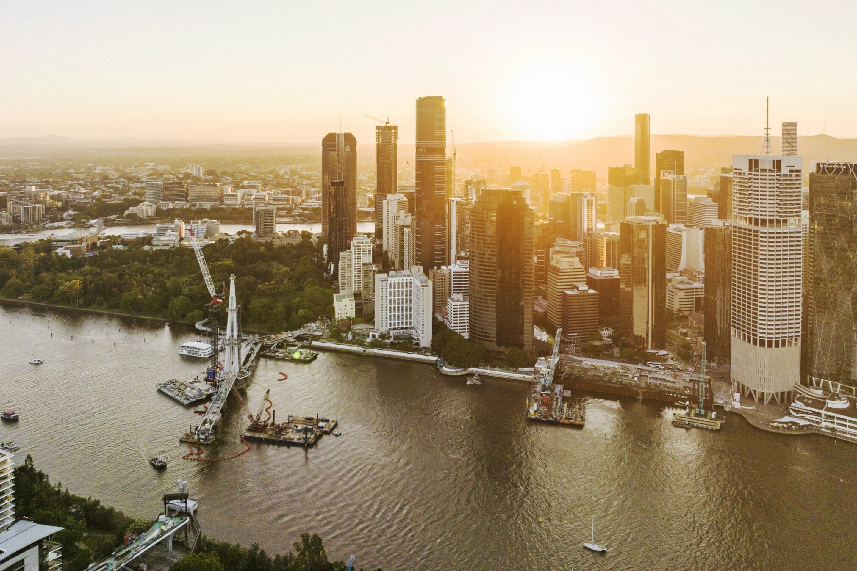 A cityscape with high-rise buildings, a river, and a bridge.