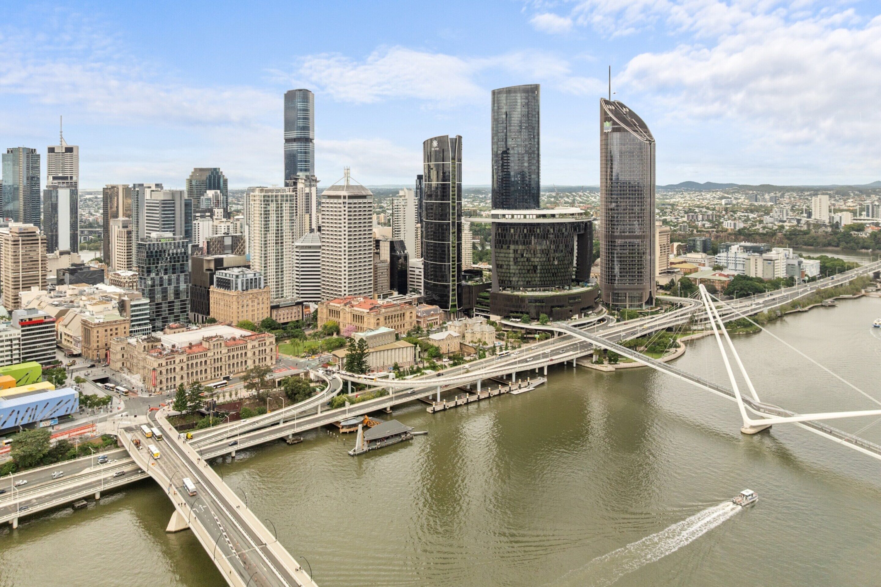 Un paysage urbain avec des gratte-ciel modernes, une rivière et un pont.