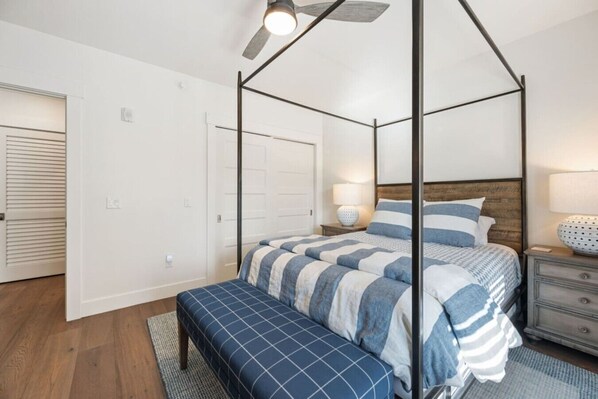 A bedroom with a four-poster bed, a bench, a nightstand, and a ceiling fan. - Marina Views & Walkable Sister Bay Condo- Paddle Boards & Bikes Included (Sister Bay)