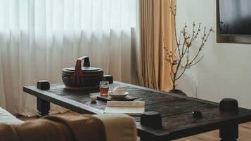 Una mesa de madera con un libro, una tetera y una taza.