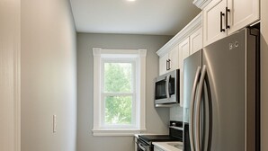 A kitchen with a stainless steel refrigerator, a microwave, and a stove. - Heated Winter Stay • 3BR Home • Pet-Friendly • Free Parking • Near Hospitals • 6 (Manchester)